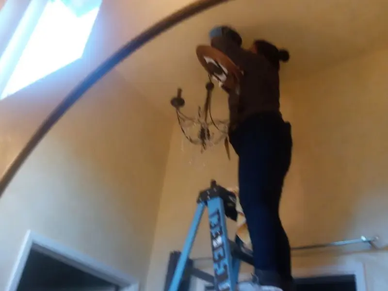 Electrician installing a chandelier in a Camino Tassajara residence